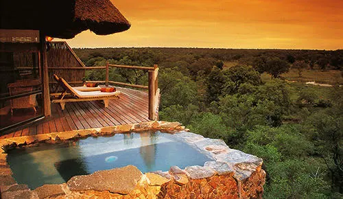 Plunge pool and viewing deck at a thatched safari lodge overlooking the bushveld at sunset, Sabi Sand, South Africa