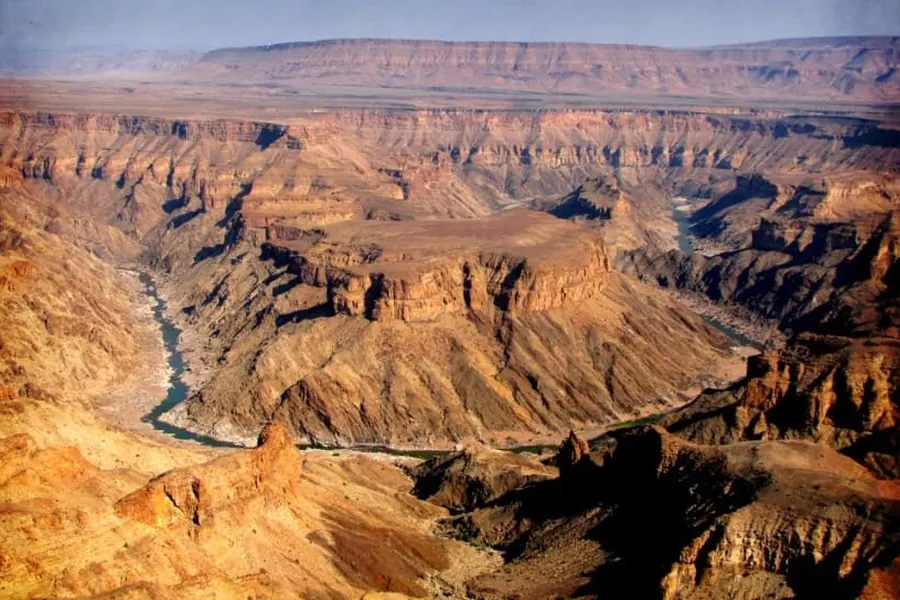 Aerial view of the Fish River winding through the vast layered rock walls of Fish River Canyon, southern Namibia