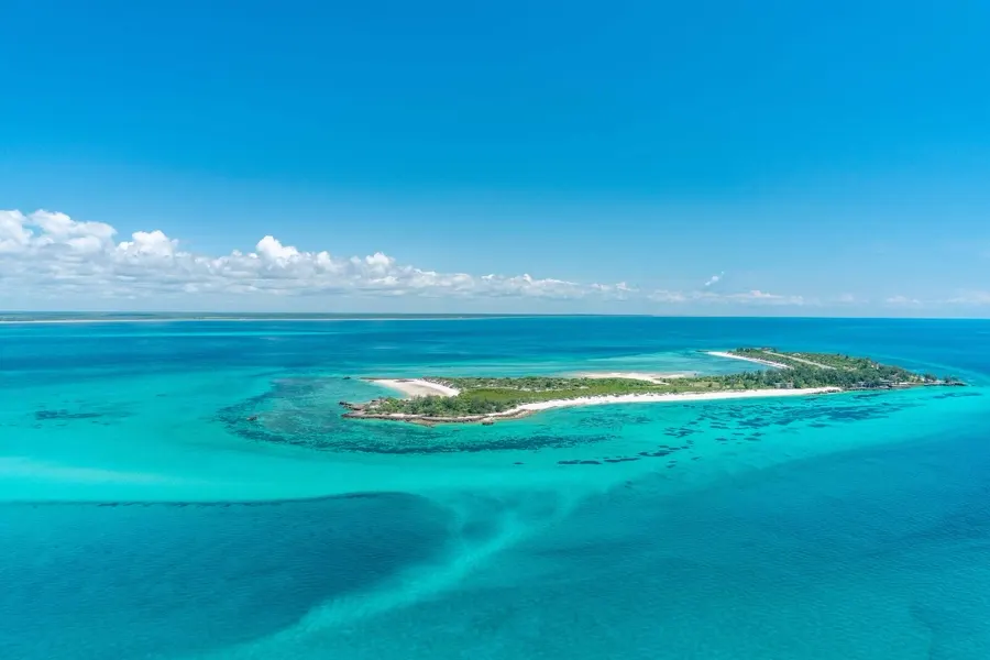 Aerial view of a coral island in the Bazaruto Archipelago ringed by turquoise sandflats and deep blue Indian Ocean