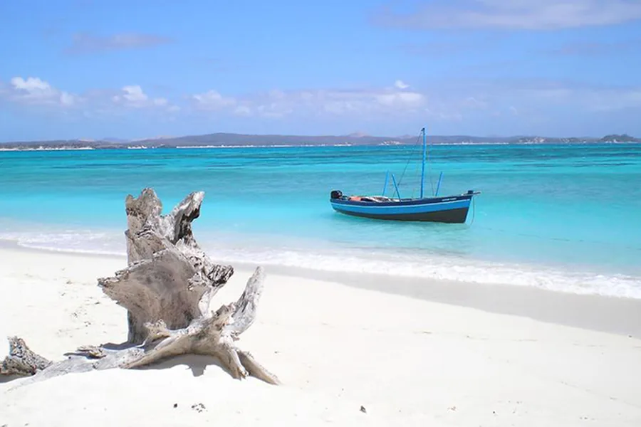 Traditional wooden fishing boat moored in the shallow turquoise water off Watamu, Kenya