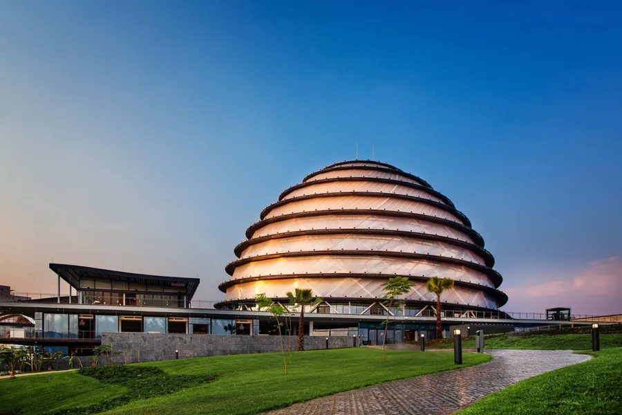 The domed Kigali Convention Centre lit at dusk above green lawns in Kigali, Rwanda